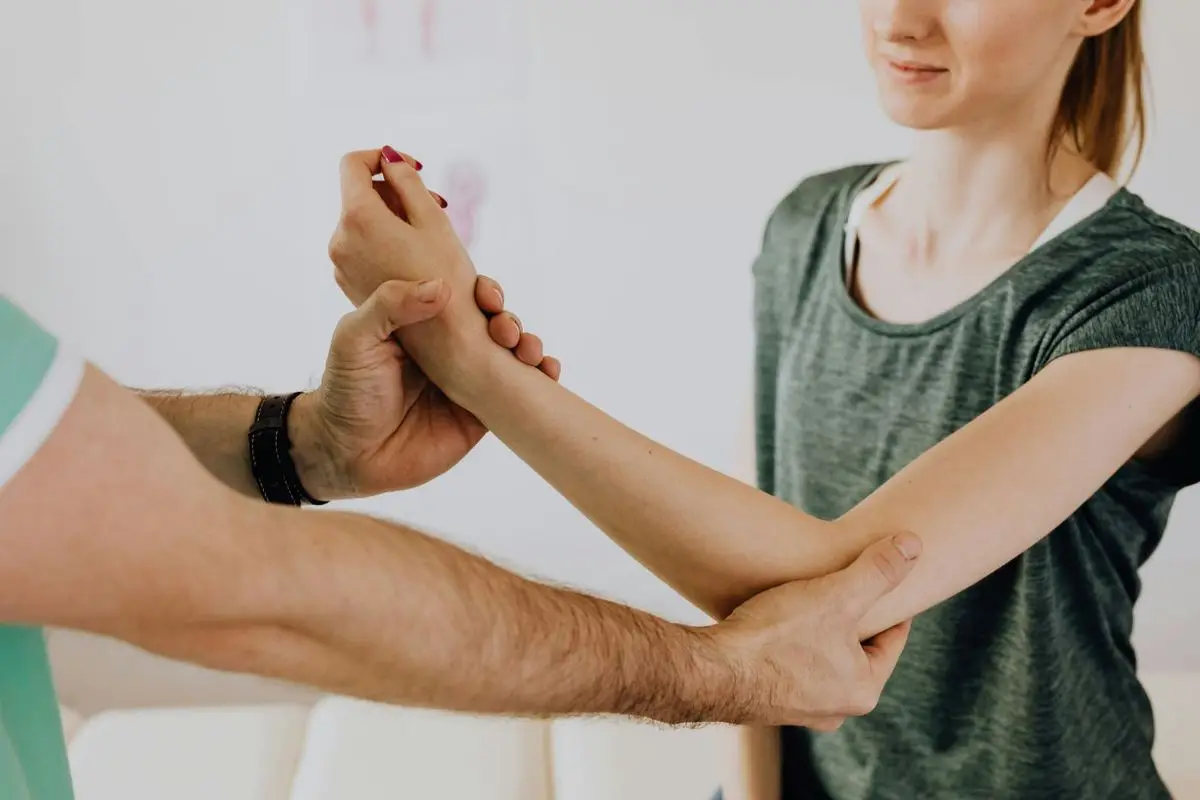 Person som håller sig om armbågen vid tennisarmbåge